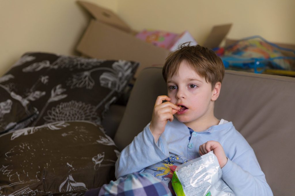 Boy eating snacks on the couch